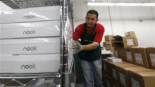 FILE - In this Dec. 11, 2012 file photo, Miguel Mercado unpacks Nook tablets at the Barnes & Noble distribution center in Monroe Township, N.J. Barnes & Noble on Thursday, Dec. 4, 2014 said it is ending its commercial agreement with Microsoft for its Nook e-book reader ahead of its planned Nook spinoff. (AP Photo/Julio Cortez, File)